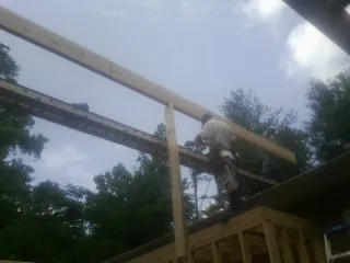 Carpenter setting a ridge beam over a new addition frame — Ice Dam Removal by Roofing Brothers in Economy