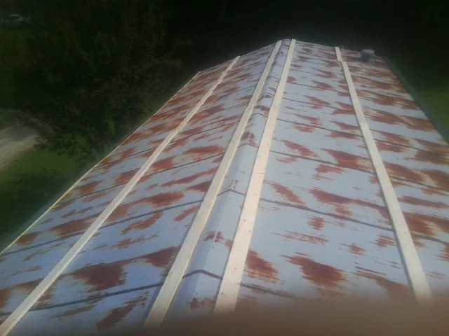 Rusted metal roof panels with new wood purlins before replacement — Storm Damage Roof Repair in Economy by Roofing Brothers