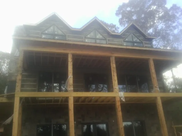 Dormers and porch framing on a large log home under construction — Roof Coating work by our crew in Economy