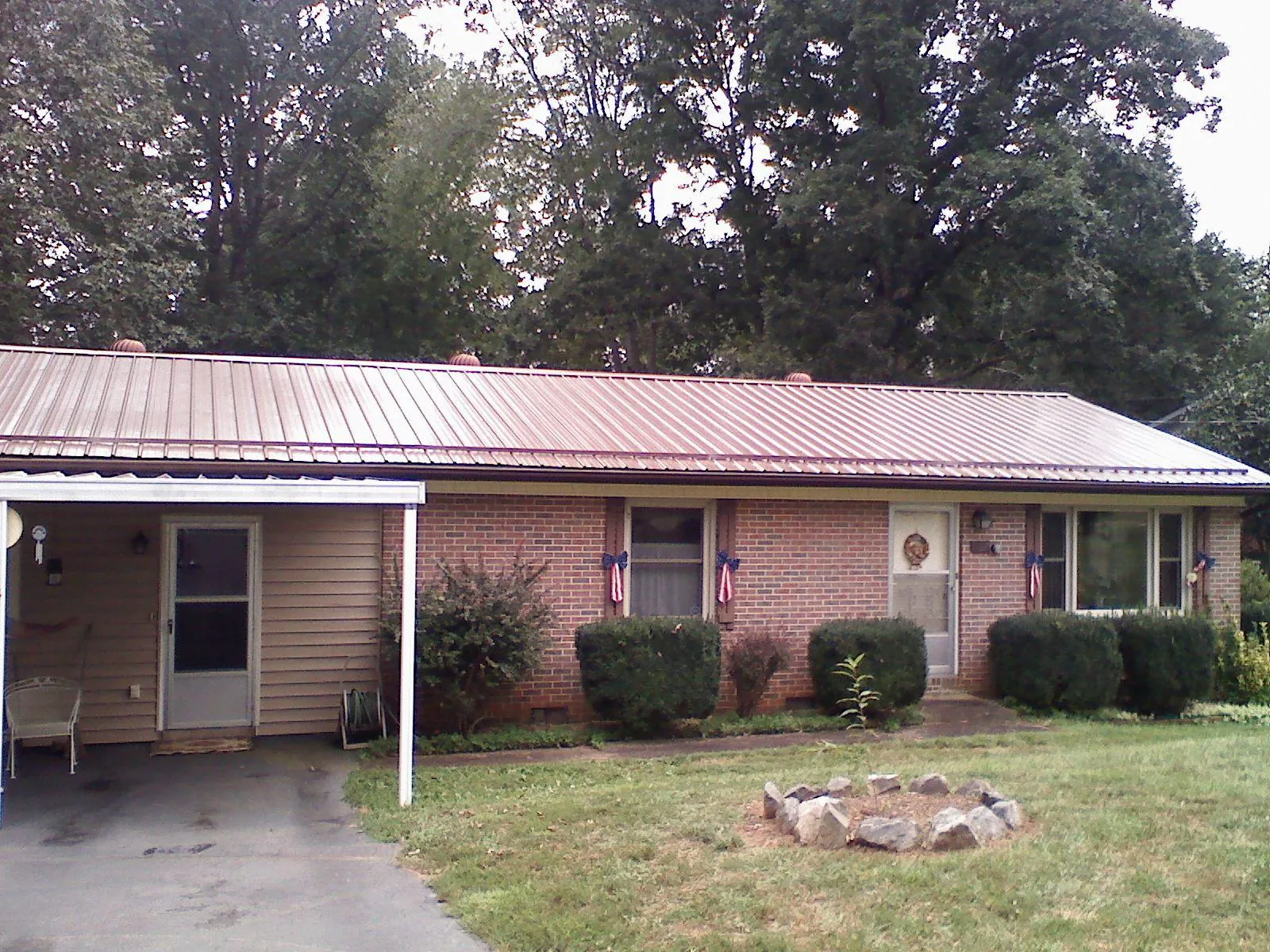 Bronze metal roof and carport on a brick ranch home — Roof Repair work by our crew in Economy
