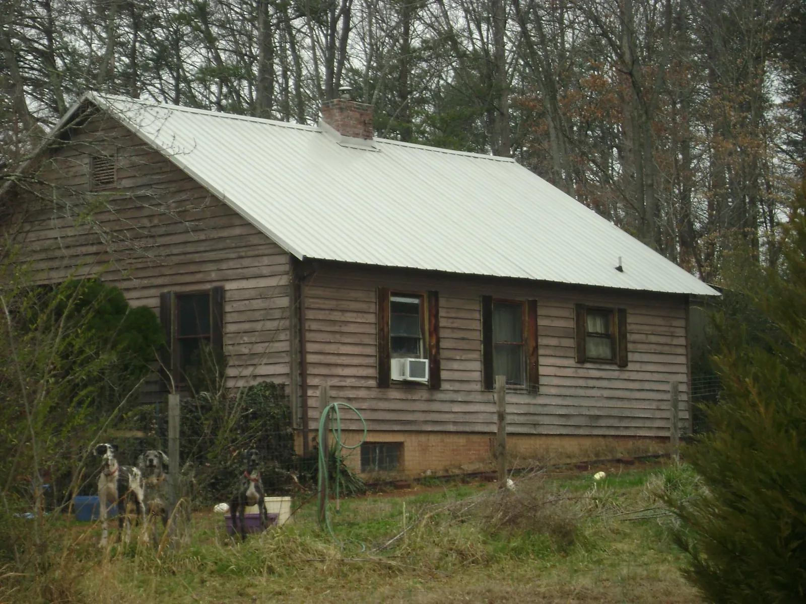 White metal roof on an old wood sided farmhouse, from a Metal Roof Installation job in Economy